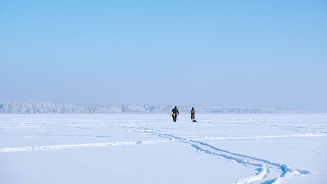 A lone fisherman on a frozen lake. Ice fishing.