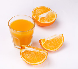 Glass of orange juice and slices of orange fruit on white background