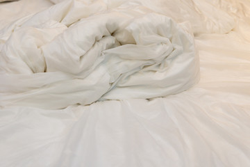 Obraz premium bed in a hotel room with unfolded quilt in the morning