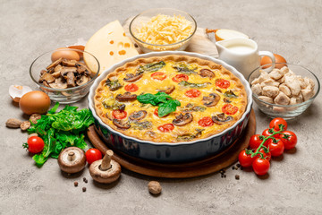 Baked homemade quiche pie in ceramic baking form, eggs and cream