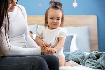 Young mother with her cute little daughter at home