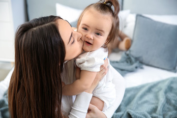 Young mother with her cute little daughter at home