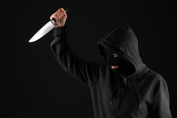 Bandit with knife on dark background