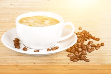 Coffee cup and coffee beans on wooden background