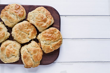 Fresh buttermilk southern biscuits or scones over a white table shot from above. Top view.