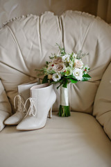 wedding bouquet of the bride and shoes, white and pink roses, chamomile flowers