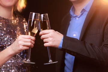 Image of woman in brilliant dress and men with wine glasses with champagne on black background