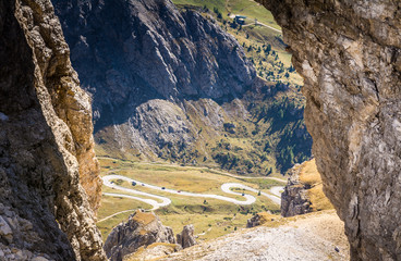 a rock windows from the Sass Pordoi plateau in Dolomites, Trentino Alto Adige, northern Italy, Europe. View of the pass Pordoi with serpentines leading to the Sella Mountains group