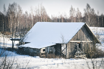 rustic weathered wood barn in the snow