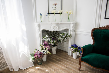 fireplace with flowers on it and vases in bright room