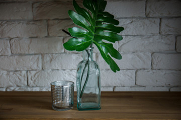 the palm leaves stand in a green vase on wooden shelf