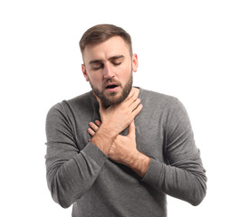 Young man having asthma attack on white background
