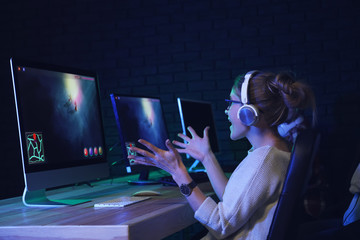 Emotional young woman playing computer game in club