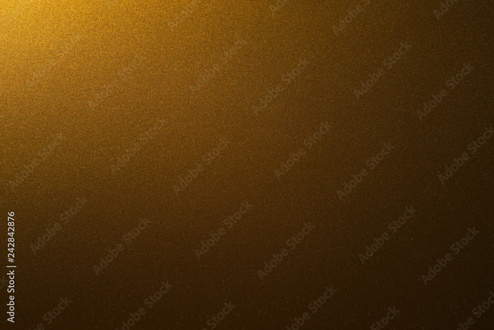 Poster golden shiny background illuminated by a single light source from the edge . golden paper dark gradi