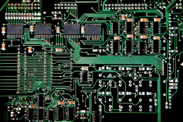 Printed Circuit board from a computer in black with green lines depicting connections.