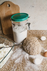 Kitchen still life. Dough, flour and eggs are on tabletop