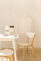 Workplace for sewing and needlework in a bright room with white furniture.