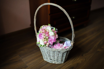 Fototapeta na wymiar bride's bouquet of red and pink roses in a wicker basket