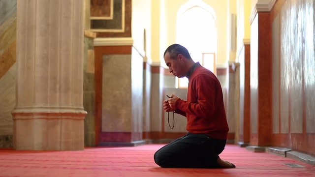 Muslim man worship with prayer beads or rosary at mosque