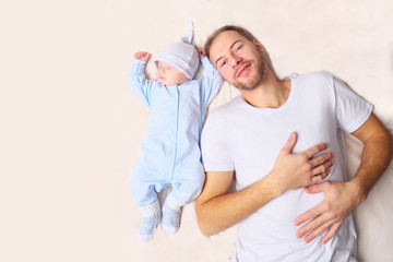 Father lying near sleeping baby