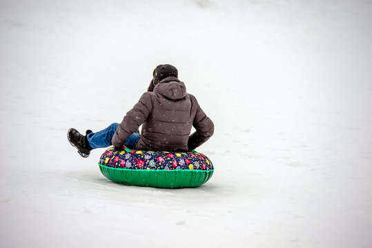 A man sledges in the snow from the hill in the winter