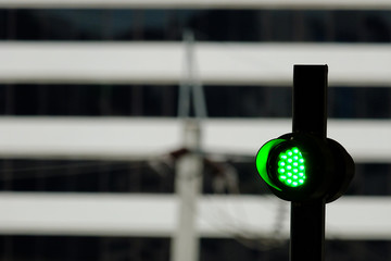 Green light sign at sky train station with blur building background