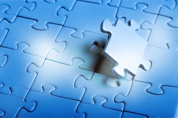 Female fingers fitting last white puzzle piece. Concept image of