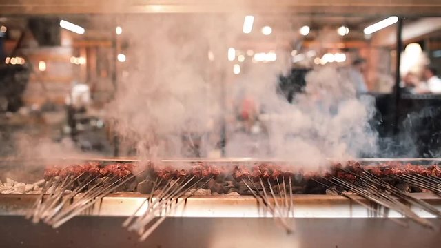 Barbecued and shished turkish kebab on the metal skewer with meat smokes.