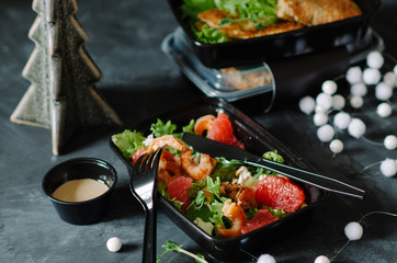 Salad with grapefruit, shrimps and lettuce. Healthy food and diet concept, restaurant dish delivery. Take away of fitness meal. Weight loss nutrition in boxes.