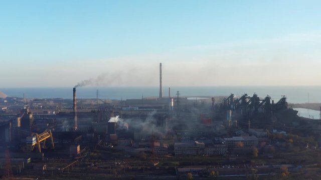 Blast furnaces by the sea. Shot from a bird's eye view. Evening time