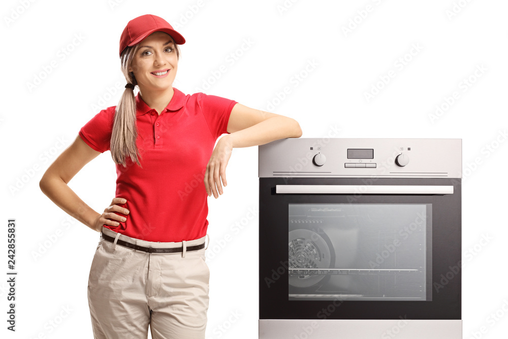 Wall mural female sales manager standing next to an electrcal oven