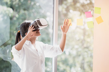 Virtual reality interaction headset by Asian Beautiful young female wearing touching air during VR...