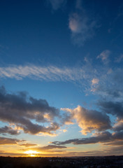 Sunset over town with blue sky and clouds