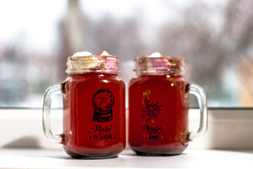 Mugs with chocolate and  ginger cookies on a wood desk with different lights