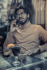 Cheerful young male person sitting at the table