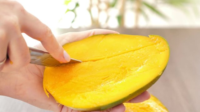 Cutting ripe mango on cubes slices , closeup