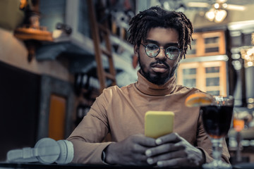Attentive brunette male person using his gadget