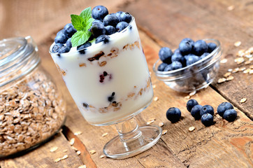Homemade yogurt with oatmeal, fresh blueberries and mint leaves