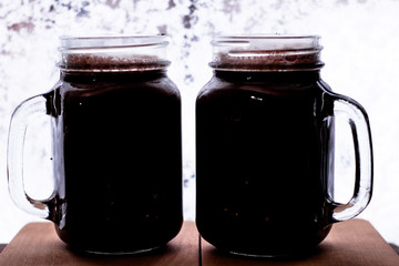 Mugs of chocolate on a wood table near window