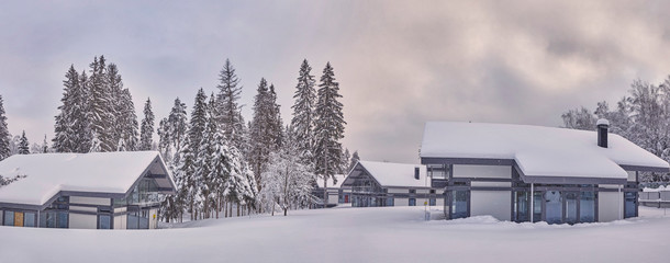 Wooden Finnish house in winter forest covered with snow