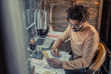 Concentrated bearded man sitting at his workplace