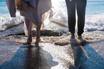 Couple of newlyweds in love celebrating their love splashing on the shore of the beach.