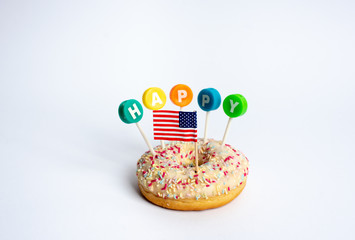 a colorful donut with the word HAPPY and the united states flag on a white background