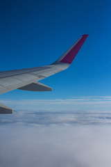 Fototapeta premium The wing of the plane in the clouds
