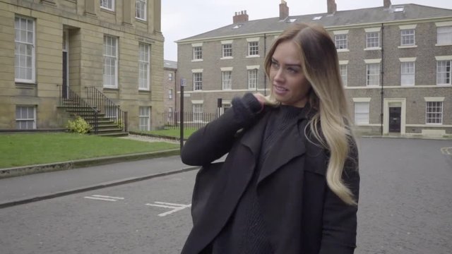 strong confident woman walks in city street slow motion happy
