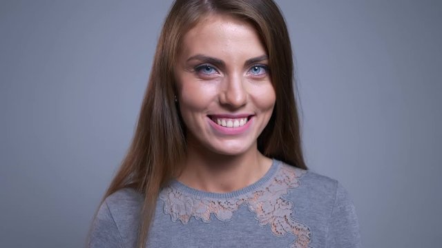 Closeup portrait of seductive young caucasian female smiling winking and looking at camera