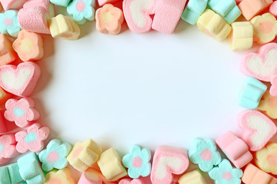 Top View of Many Pastel Color Flower Shaped and Heart Shaped Marshmallow Candies with Free Space for Text and Design 