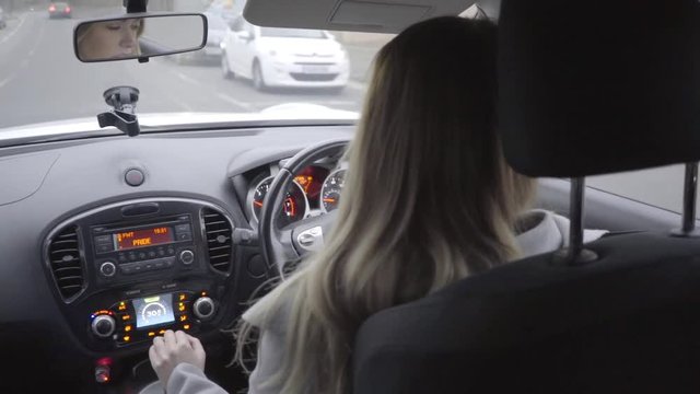 attractive woman driving car in city daytime in winter slow motion