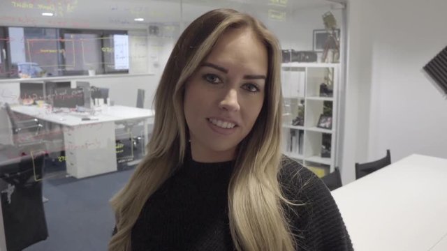 confident attractive blonde business owner smiles at camera