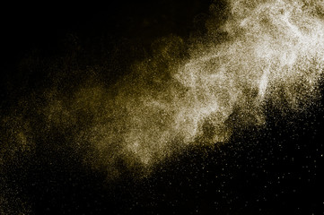 Fototapeta na wymiar golden powder color spreading effect for makeup artist or graphic design in black background